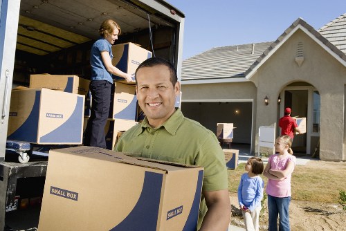Professional movers carrying furniture from a Clapham property